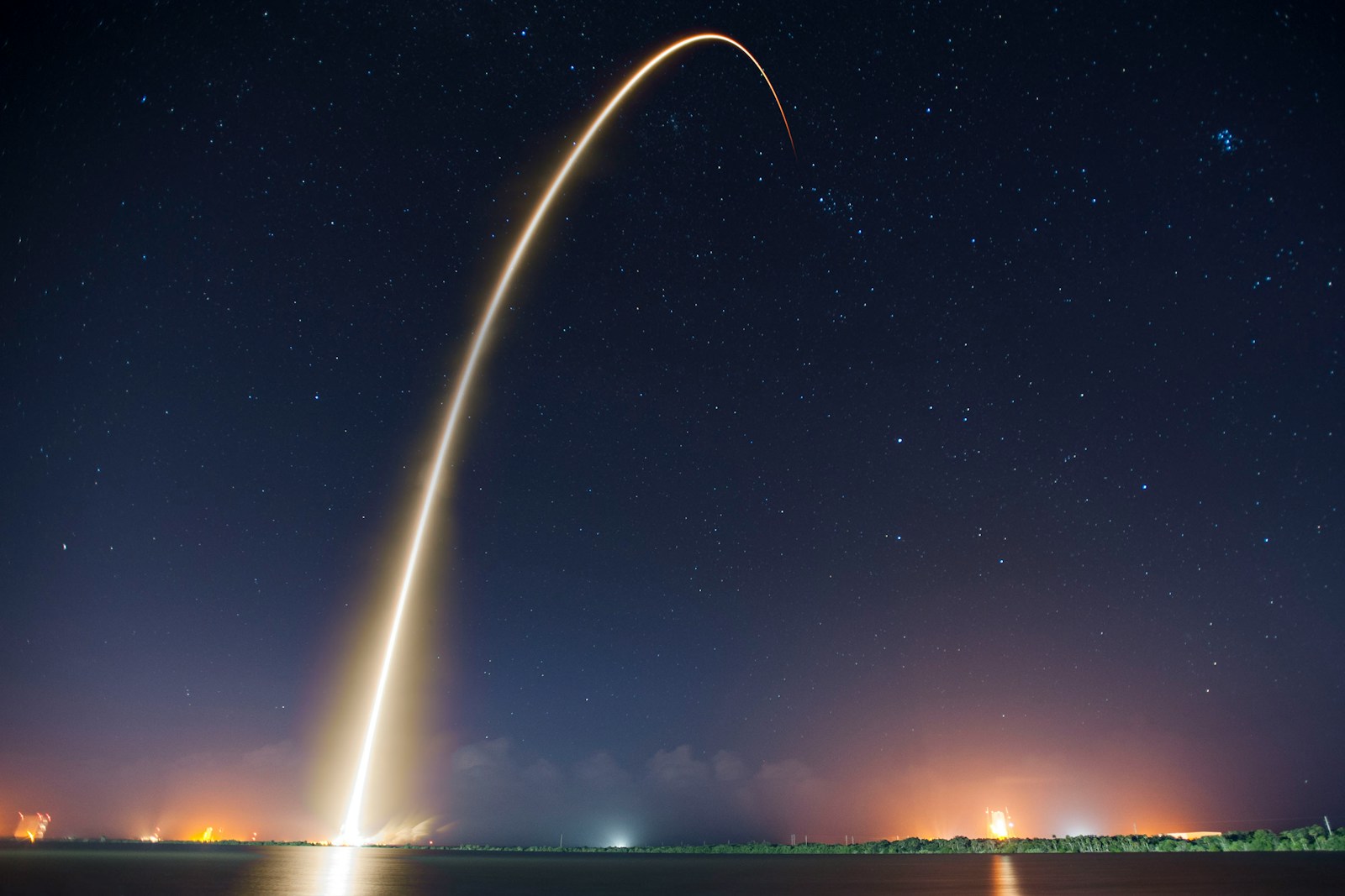 A rocket launch arcing into the night sky